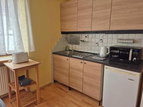 a kitchen with wooden cabinets and a black counter top at Apartment Ad Alta - Matschiedl 1 in Hermagor