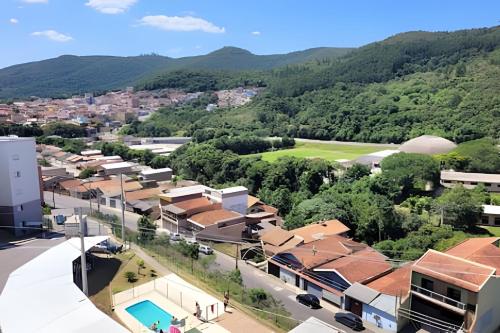 Una vista aérea de una ciudad con montañas al fondo. en Cond. Mirante da Serra -, en Poços de Caldas
