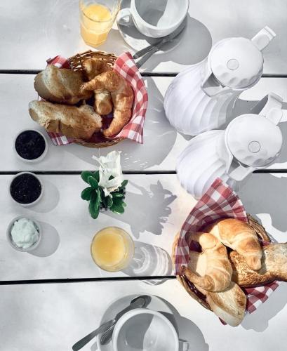 een tafel met een bord gebak en kopjes koffie bij La Martineta Posada de Campo in Capilla del Señor