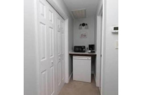 a hallway with white doors and a kitchen with a counter at Litchfield Beach & Golf Resort in Pawleys Island