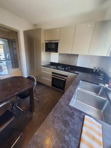 une cuisine avec un évier et un plan de travail dans l'établissement T3 avec parking et balcon-Groupama Stadium-Eurexpo, à Le Carreau