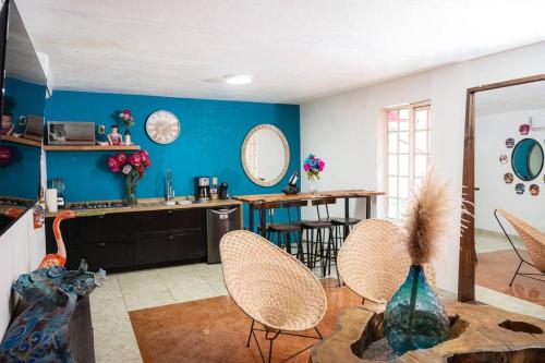 a kitchen with chairs and a blue wall at Casa Flamingos en el centro de Tlaquepaque in Guadalajara