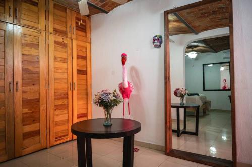 a room with a table with a vase of flowers at Casa Flamingos en el centro de Tlaquepaque in Guadalajara