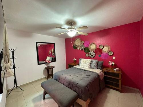 a bedroom with a bed and a pink wall at Casa Flamingos en el centro de Tlaquepaque in Guadalajara