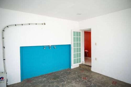 an empty room with a blue wall and a door at Casa Flamingos en el centro de Tlaquepaque in Guadalajara