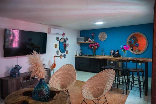 a living room with blue walls and a table and chairs at Casa Flamingos en el centro de Tlaquepaque in Guadalajara