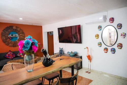a living room with a table with a vase with flowers at Casa Flamingos en el centro de Tlaquepaque in Guadalajara