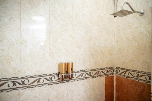 a shower with a glass door and a shower head at Casa Flamingos en el centro de Tlaquepaque in Guadalajara
