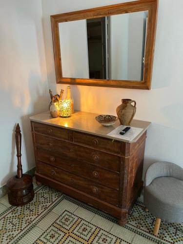 a dresser with a mirror and a chair in a room at Bed&Breakfast Al Campanario in Cómpeta