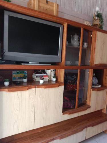 a television in a wooden entertainment center at gite du guip in Trégourez