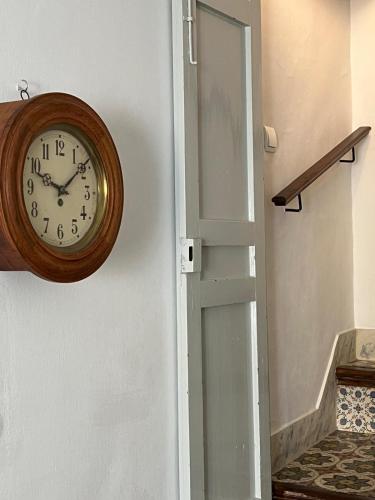a clock hanging on a wall next to a door at Bed&Breakfast Al Campanario in Cómpeta
