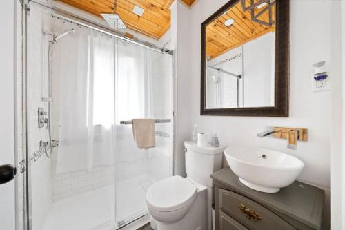 a bathroom with a shower and a toilet and a sink at Westlake waterfront, hot tub, dock,4 mins to beach in West Lake