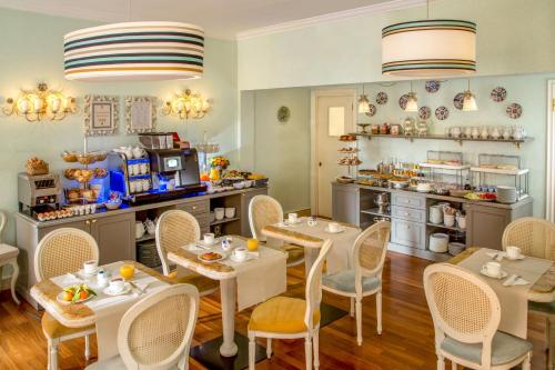 a dining room with tables and chairs and a kitchen at Hotel Mozart in Rome