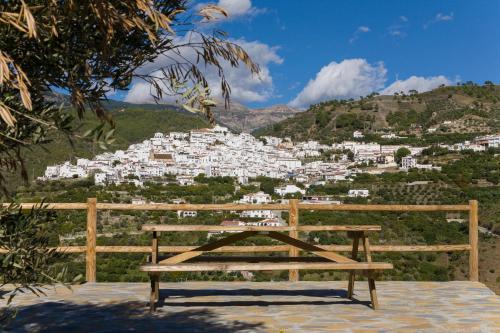 a wooden bench sitting on top of a hill at Bed&Breakfast Al Campanario in Cómpeta