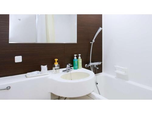 a white bathroom with a sink and a mirror at Miyakonojo City Hotel - Vacation STAY 15153v in Miyakonozyō