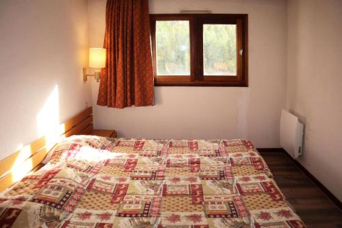 une chambre avec un lit avec une couette dessus dans l'établissement Résidence Le Belvedere - APPARTEMENT N° 706 LE BELVEDERE MAE-4054, aux Orres