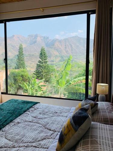a bedroom with a bed and a large glass window at Casa Tinta & hierro in Naranjo