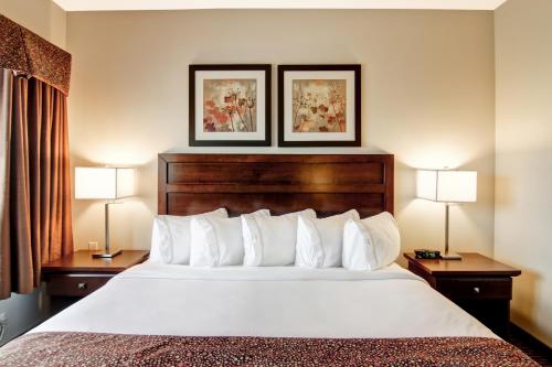 a hotel room with a large bed with two lamps at Canalta Hotel Melfort in Melfort
