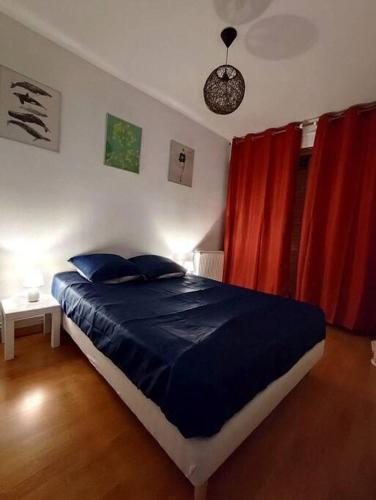 - une chambre avec un lit bleu et des rideaux rouges dans l'établissement Idéalement situé pour tous III, à Dijon