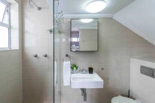 a bathroom with a shower and a sink and a toilet at Simple Studio in Sea Point in Cape Town
