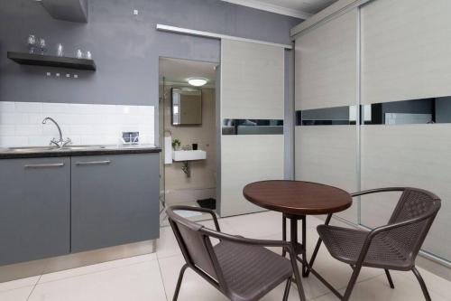 a kitchen with a wooden table and two chairs at Simple Studio in Sea Point in Cape Town