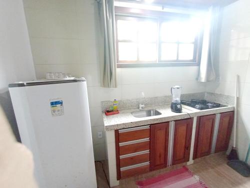 a small kitchen with a sink and a refrigerator at Pousada Lagoa Flat in Morro de São Paulo
