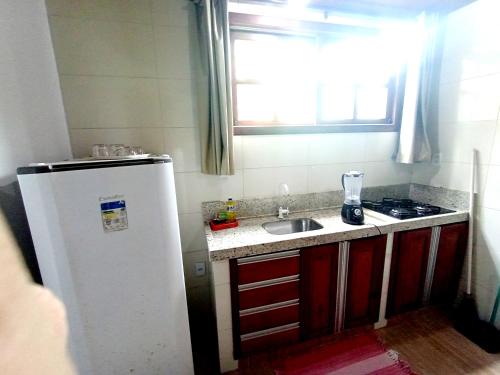 a small kitchen with a sink and a refrigerator at Pousada Lagoa Flat in Morro de São Paulo