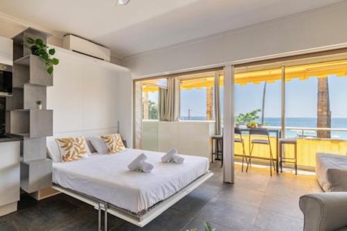 une chambre avec un lit et une vue sur l'océan dans l'établissement Beach Front Studio - Western Cannes, à Cannes
