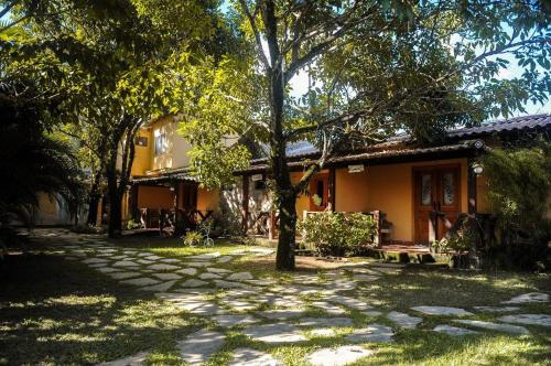 a house with a stone path in front of it at Pousada Casa Mendes in Guapimirim