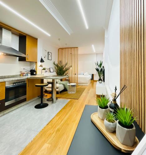 Una cocina y una sala de estar con una mesa y plantas en macetas. en Las Terrazas de Vigo - David, en Vigo