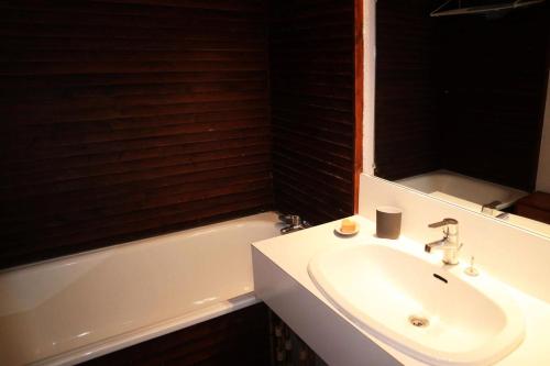 La salle de bains est pourvue d'un lavabo et d'une baignoire avec un miroir. dans l'établissement Résidence L'oustal - Grand studio 4 personnes MAE-0121, aux Orres