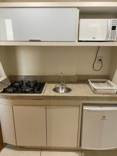 una cucina con piano cottura, lavello e forno a microonde di Inova Flat no centro a Palmas
