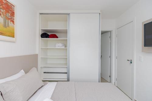 Un dormitorio blanco con una cama y un armario. en Apto de 1 Quarto com Sofá-Cama na Sala - LHP1004, en Curitiba