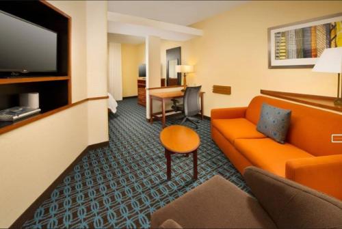 a hotel room with an orange couch and a desk at Fairfield Inn & Suites by Marriott Waco North in Waco