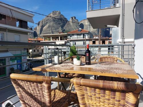a wooden table with a bottle of wine on a balcony at Aquarium House in Kalabaka