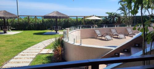 a resort with a deck with chairs and umbrellas at Apart Hotel Beira do Mar in Florianópolis