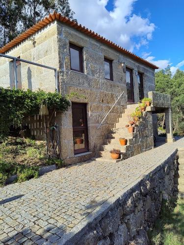 a stone house with stairs leading to a building at Casa de Gondomil in Alpendurada