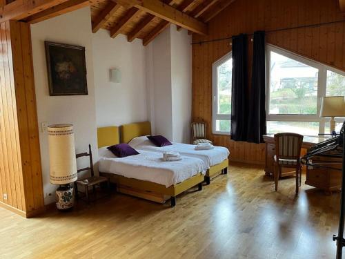 une chambre avec un lit et une grande fenêtre dans l'établissement Villa au calme entre lacs et montagnes, à Pers-Jussy