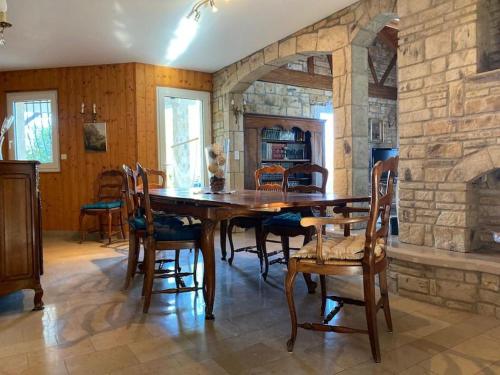 une salle à manger avec une grande table et des chaises en bois dans l'établissement Villa au calme entre lacs et montagnes, à Pers-Jussy