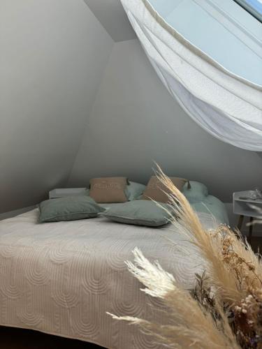 a bed in a room with a window and a bed with grass at Plaisirs Normands in Saint-Julien-de-Mailloc