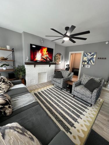 a living room with a fireplace and a ceiling fan at Charming 2BR 2BA 10 min DT Airport by LSP Homes in Atlanta