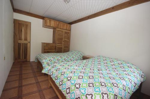 a bedroom with a bed with a colorful comforter at Hospedaje Yarisnori in Bocas del Toro