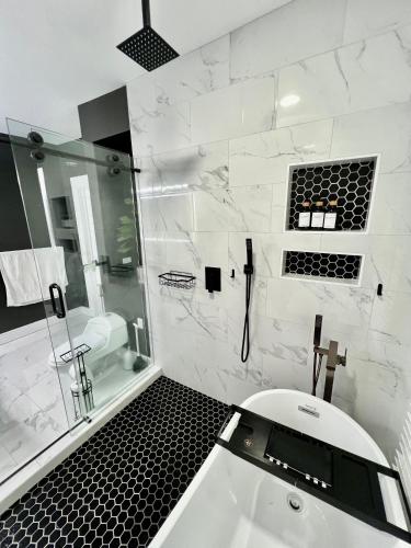 a bathroom with a tub and a shower and a sink at Charming 2BR 2BA 10 min DT Airport by LSP Homes in Atlanta