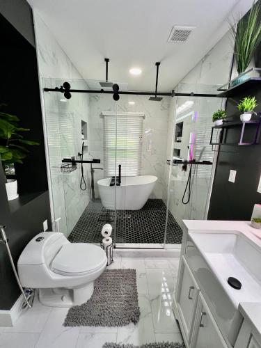 a bathroom with a tub and a toilet and a shower at Charming 2BR 2BA 10 min DT Airport by LSP Homes in Atlanta