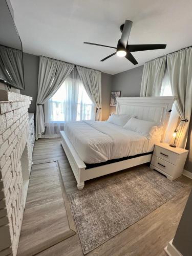 a bedroom with a white bed and a ceiling fan at Charming 2BR 2BA 10 min DT Airport by LSP Homes in Atlanta