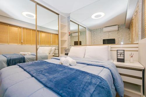 Un dormitorio con dos camas y un gran espejo. en Apartamento 1 Quarto Lindíssimo, Garagem - SEV2402, en Curitiba
