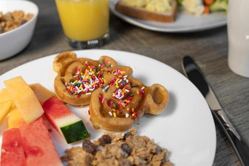 a plate of food with donuts and fruit on a table at Magic Moment Resort and Kids Club in Kissimmee