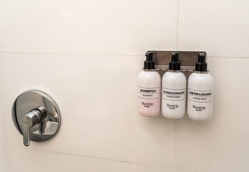 two bottles of disinfectant are hanging on a wall at RentUp Suites Salta in Salta