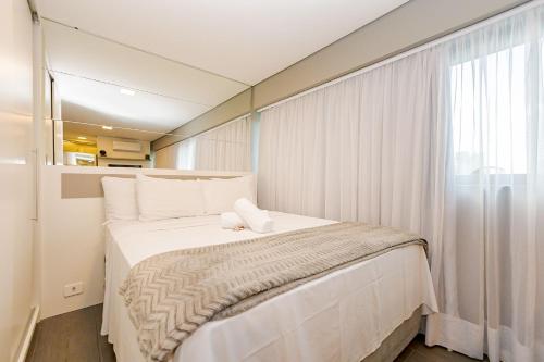 Un dormitorio con una cama grande con ventana. en Studio para 4 pessoas no Seventh - SEV0702, en Curitiba