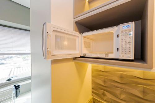 una cocina con un horno microondas en una cocina en Studio para 4 pessoas no Seventh - SEV0702, en Curitiba